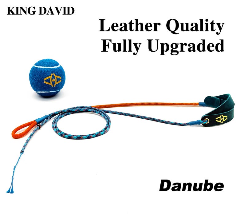 Puede incluir: Una pelota de tenis azul con un logotipo amarillo, una correa de cuerda trenzada larga de color naranja y azul, y un asa de cuero verde oscuro con un logotipo amarillo. El texto dice: KING DAVID, Leather Quality Fully Upgraded y Danube.