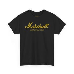 Op de afbeelding: Zwart t-shirt met de gouden tekst "Marshall AMPLIFICATION". Het t-shirt heeft een ronde hals en korte mouwen. Het Marshall-logo is een belangrijk designelement, geschikt voor muziekliefhebbers.