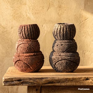 May include: Two stacks of three porous, textured stone bowls, one stack in reddish-brown and one in dark charcoal gray. Each bowl features carved vertical or curved line patterns. The text FiveCosmos is visible in the bottom right corner.