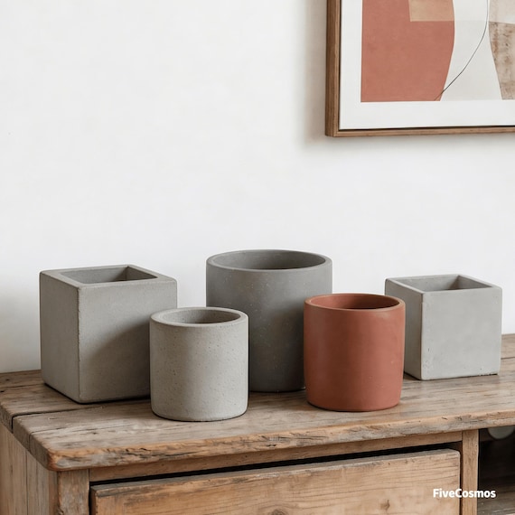 Hand-cast geometric concrete planters with angular, architectural forms — the kind of desktop object that looks like it belongs in a design magazine.