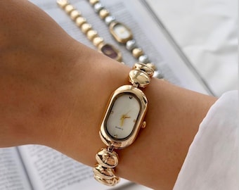 Reloj de pulsera ovalado dorado para mujer: elegante reloj de pulsera con correa de aleación metálica.