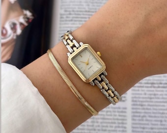 Reloj de mujer bicolor: delicado reloj de pulsera con brazalete en tonos dorados y plateados.