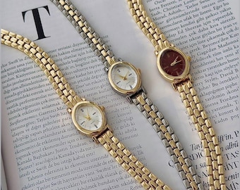 Elegante reloj de pulsera ovalado bicolor dorado para mujer.