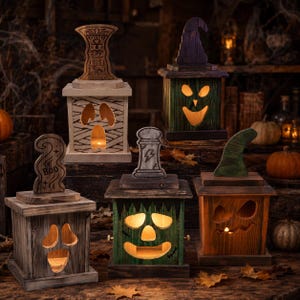 May include: Five wooden box lanterns with cutout faces and various toppers. One is wrapped like a mummy, one is green with a witch hat, one is grey with 'BOO' text, one is green with a tombstone, and one is brown with a green hat.