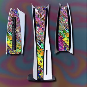 Puede incluir: Una consola PlayStation 5 blanca con placas frontales con diseños psicodélicos coloridos. La consola se muestra desde múltiples ángulos, destacando el diseño vibrante y abstracto en tonos de amarillo, verde, morado y naranja. La consola está sobre un fondo oscuro.