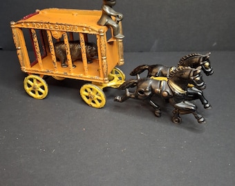 Carroça antiga Hubley Royal Circus em ferro fundido, laranja, 1910, com gaiola para ursos e dois cavalos.