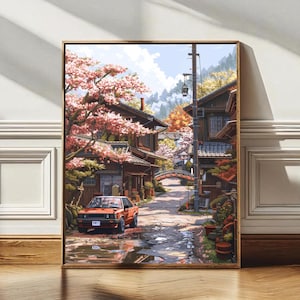 Könnte beinhalten: Ein gerahmter Kunstdruck zeigt eine japanische Dorfszene. Ein rotes Auto parkt auf einer nassen Kopfsteinpflasterstraße. Kirschblütenbäume umrahmen traditionelle Holzgebäude. Eine Brücke spannt sich über einen Bach, mit Bergen im Hintergrund.
