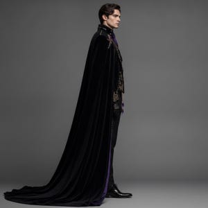 Puede incluir: Una capa de terciopelo negro hasta el suelo con intrincados bordados dorados en los hombros y el cuello, combinada con una chaqueta negra a juego, pantalones oscuros, guantes de cuero negro y zapatos de vestir negros, con forro morado.