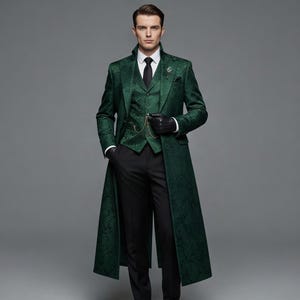 Puede incluir: Un traje verde de tres piezas con un abrigo largo. El traje presenta un diseño estampado, un chaleco y una corbata negra. La persona lleva guantes negros y sostiene un reloj de bolsillo. Los pantalones son negros.