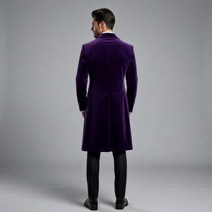 Pu&ograve; includere: Un lungo cappotto di velluto viola scuro dal design classico. Il cappotto presenta una vestibilit&agrave; sartoriale, maniche lunghe e chiusura con bottoni. La persona indossa pantaloni neri e scarpe nere.