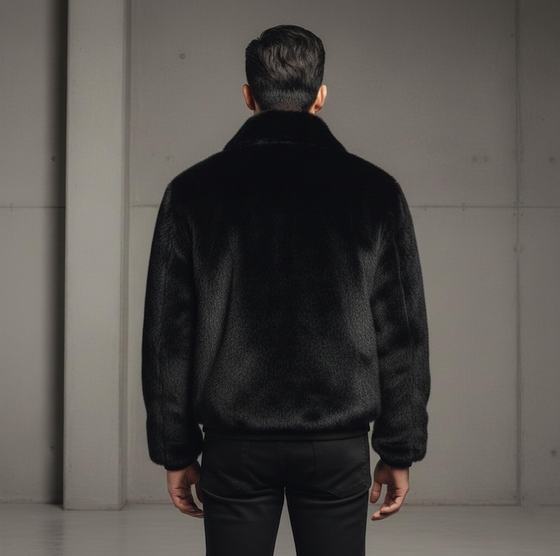 May include: A black faux fur bomber jacket with a classic collar and ribbed cuffs and hem. The jacket is shown from the back, with a focus on the texture and sheen of the fur. The jacket is paired with black pants.