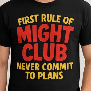 May include: Black crew neck t-shirt with the text "FIRST RULE OF MIGHT CLUB NEVER COMMIT TO PLANS" in yellow and red. The shirt is worn by a person in blue jeans.