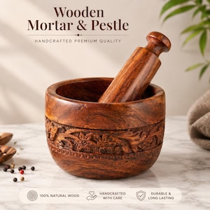 Könnte beinhalten: Ein dunkelbraunes Holz-Mörser- und Stößel-Set. Der Mörser hat geschnitzte Blumenmuster um die Schüssel. Der Stößel ist zylindrisch mit einem abgerundeten Griff. Der Text "Wooden Mortar & Pestle" befindet sich oben.