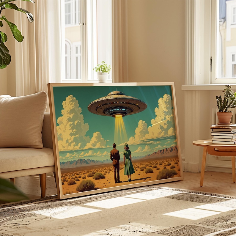 May include: A framed art print depicting a retro scene of a couple standing in a desert landscape, gazing at a hovering UFO. The artwork features a mid-century modern style with a blue sky, clouds, and a beam of light.