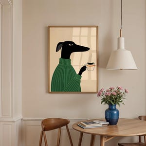 May include: A framed art print depicting a black dog in a green sweater, holding a coffee cup. The dog has a long snout and is illustrated in a minimalist style. The background is a neutral beige, and the frame is a warm brown.