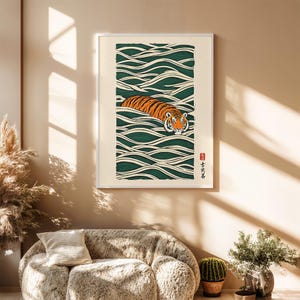 May include: Framed art print featuring a tiger swimming in stylized green and white waves. The tiger has orange and black stripes with a white face. Japanese characters are in the lower right corner. The artwork is in a white frame.