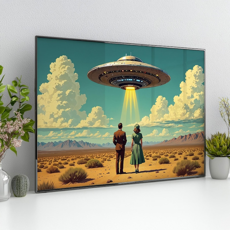 May include: A framed art print depicts a retro-style scene of a couple gazing at a hovering UFO. The artwork features a desert landscape under a blue sky with fluffy clouds. The UFO emits a bright yellow beam of light.