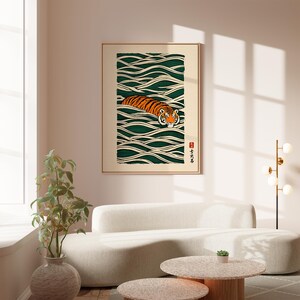 May include: Framed art print featuring a tiger swimming in stylized green and white waves. The tiger has orange and black stripes with a white face. The artwork is in a gold frame and includes Japanese text and a red seal.