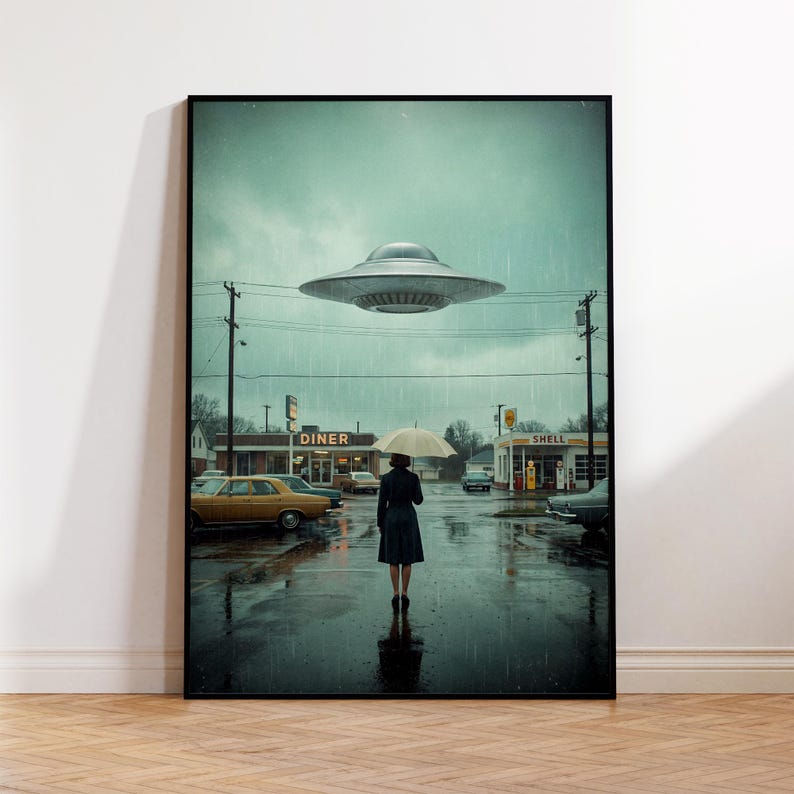 May include: A framed art print showing a rainy street scene with a diner and petrol station. A person with an umbrella walks towards the viewer. A silver UFO hovers in the sky. Classic cars are parked along the street.