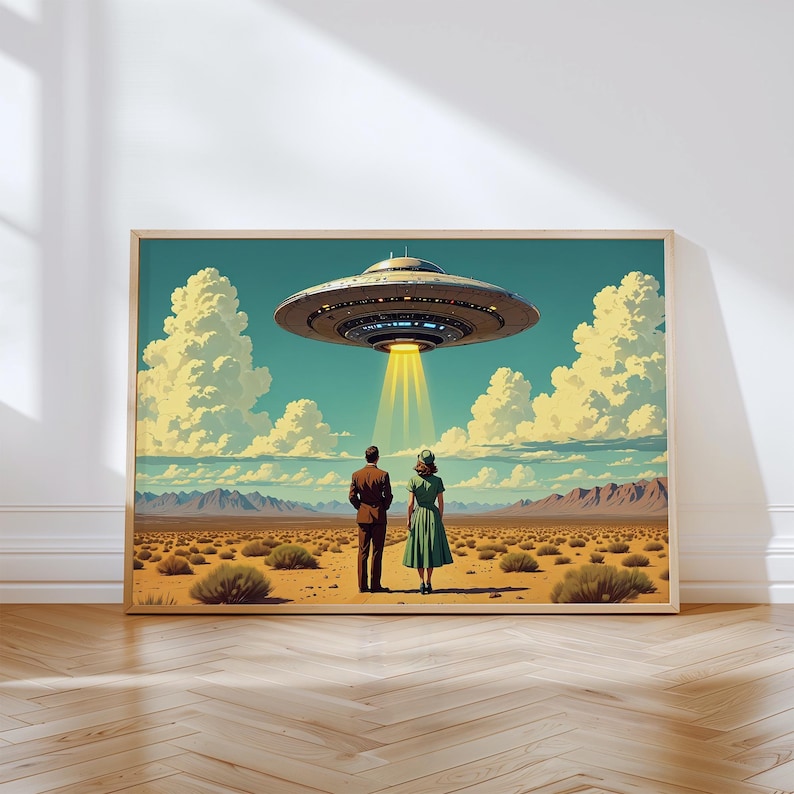 May include: A framed art print depicts a retro scene of a couple gazing at a hovering UFO. The artwork features a desert landscape under a blue sky with fluffy clouds. The UFO emits a bright yellow beam of light.