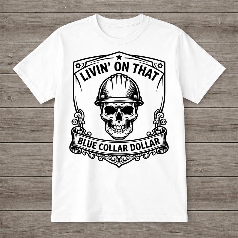 May include: White t-shirt featuring a black and white graphic. The graphic includes a skull wearing a hard hat, surrounded by the text "LIVIN' ON THAT" and "BLUE COLLAR DOLLAR" in a decorative frame.