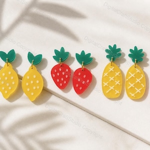 May include: A collection of colorful fruit-shaped earrings. The earrings include lemon, strawberry, and pineapple designs. The lemons are yellow with white dots, the strawberries are red with white dots, and the pineapples are yellow with white crosshatch patterns.