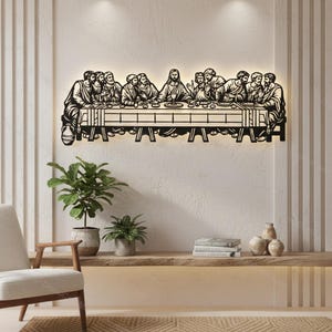 May include: A black metal wall art piece depicting The Last Supper, featuring Jesus and his twelve disciples seated at a long table. The design is backlit, creating a glowing silhouette effect against the wall, showcasing detailed figures.