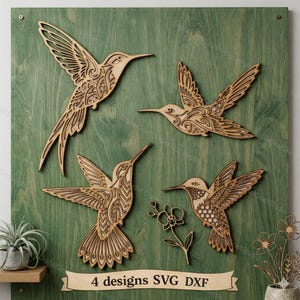 May include: Four wooden hummingbird designs are displayed on a green painted wooden board. The hummingbirds are intricately cut with detailed patterns. A banner at the bottom reads "4 designs SVG DXF".