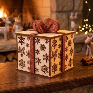 Peut inclure: Une boîte cadeau carrée en bois avec une finition en bois clair et des motifs de flocons de neige et de branches de pin découpés au laser en brun foncé. Elle est ornée de bandes rouges verticales et d'un grand nœud rouge stylisé doré.