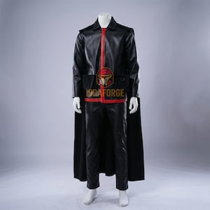May include: A black leather costume with a red stripe and accents. The outfit includes a jacket, trousers, and a cape. The IDRAFORGE logo is visible on the chest. The costume is displayed on a mannequin.