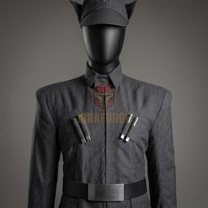 May include: A dark gray uniform jacket with a matching peaked cap, featuring a high collar, structured shoulders, and two silver-toned cylindrical accents on each side of the chest. A wide black belt with a plain silver buckle is worn at the waist.