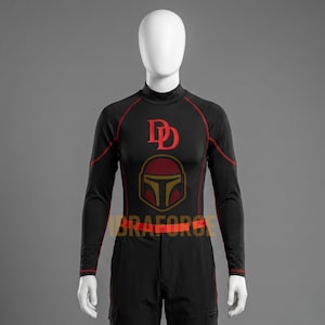 May include: Black long-sleeved top with red trim and a mock turtleneck. The shirt features a red "DD" logo and a red and gold helmet graphic on the chest. The waist has a red band. The outfit is displayed on a mannequin.