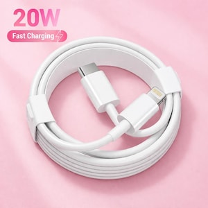 May include: White charging cable with a USB-C connector and a Lightning connector. The cable is coiled and secured with a white strap. The text "20W Fast Charging" is displayed in pink.