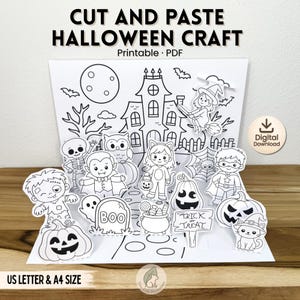 Op de afbeelding: Een zwart-wit printbare Halloween knutselset met een achtergrond van een spookhuis en diverse uitgeknipte figuren zoals een skelet, vampier, heks, superheld en pompoenen. De tekst luidt CUT AND PASTE HALLOWEEN CRAFT, Digital Download en US LETTER & A4 SIZE.