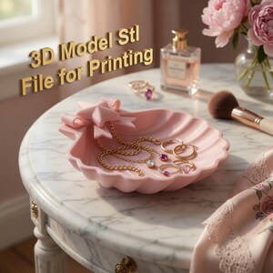 Op de afbeelding: Een roze schelpvormige sieradenschaal met een strik, met gouden kettingen en ringen met edelstenen. De schaal staat op een tafel met marmeren blad, met een parfumfles en make-upkwast op de achtergrond. Tekst op de afbeelding luidt "3D Model Stl File for Printing."