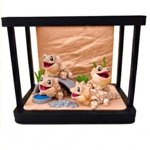 Peut inclure: Un terrarium décoratif avec quatre lézards de style cartoon, la bouche ouverte et souriants. Les lézards sont beiges avec des taches blanches, disposés autour d'un petit pont et d'un abreuvoir. Le fond est un paysage beige texturé, le tout dans un cadre noir.