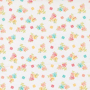 May include: White fabric with a repeating floral pattern. The design features clusters of small flowers in shades of pink, yellow, and blue, with green stems and leaves. Scattered single flowers in matching colors complete the pattern.