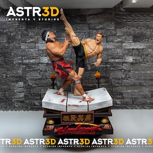 May include: A detailed statue depicting two muscular figures engaged in a martial arts fight. One figure is kicking the other. The statue is on a multi-tiered base with text and decorative elements. The statue has the text "ASTR3D" on the top and bottom.