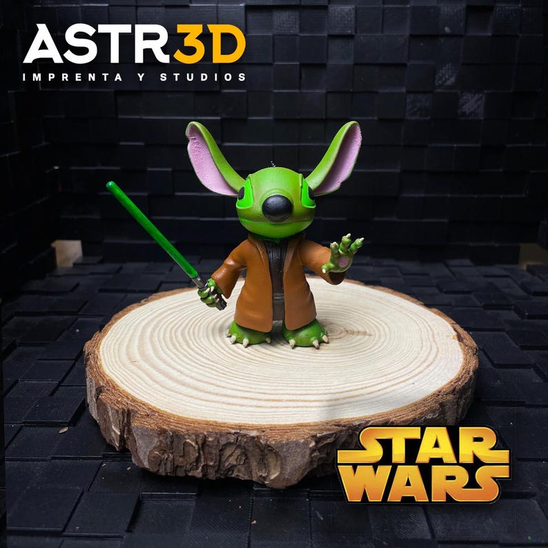 May include: A green figure with large ears, a brown coat, and a green lightsaber, standing on a wooden slice. The figure is a mashup of Stitch and Yoda. The Star Wars logo is visible.