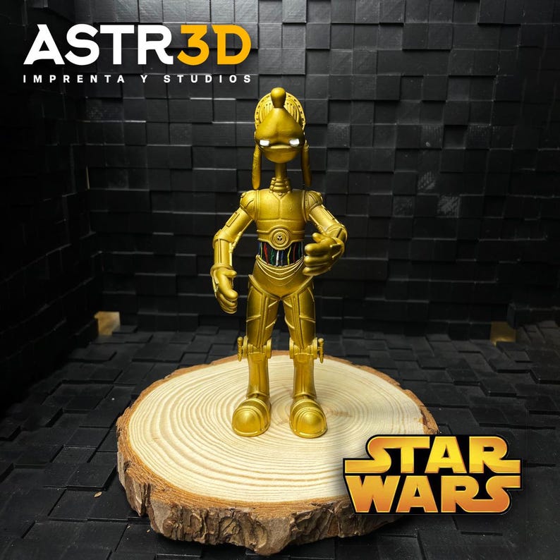 May include: A gold C-3PO figurine from Star Wars, displayed on a wooden slice. The figurine features intricate mechanical detailing. The Star Wars logo is visible. The text "ASTR3D IMPRENTA Y STUDIOS" is visible in the upper left corner.