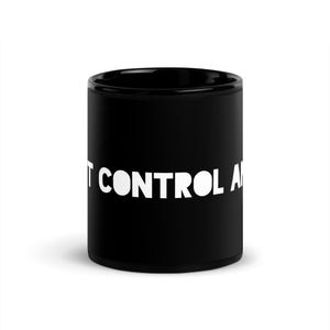 Könnte beinhalten: Eine schwarze Keramiktasse mit dem weißen Text "I CAN'T CONTROL A". Die Tasse ist zylindrisch und hat eine glänzende Oberfläche. Der Text ist auf der Tasse zentriert.