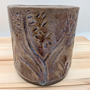 May include: A set of three ceramic mugs with a speckled, matte finish. Each mug features a different color: light blue, cream, and gray. The mugs have a simple, modern design and a comfortable handle. Perfect for coffee or tea.