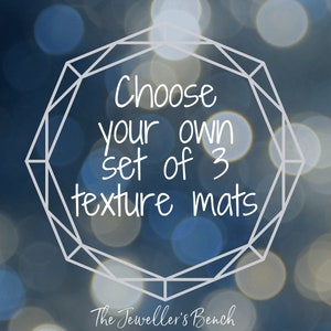 May include: A graphic design featuring a white geometric diamond outline surrounding the text "Choose your own set of 3 texture mats" with the brand name "The Jeweller's Bench" written in white script at the bottom against a blue bokeh background.