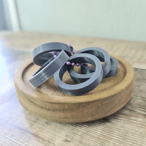 Peut inclure: Une tasse en céramique blanche avec une anse noire et l'inscription "But First, Coffee" en gras noir. La tasse est posée sur un fond flou, suggérant un cadre chaleureux.