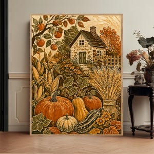 May include: A framed wall art print featuring a rustic stone cottage surrounded by an autumn harvest scene. The illustration includes orange pumpkins, yellow corn stalks, a bundle of wheat, and an apple tree with red fruit in a warm color palette.