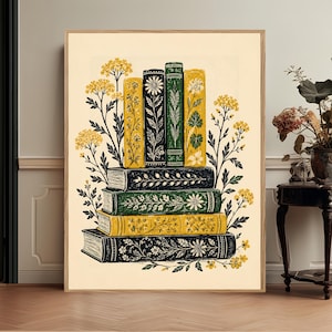 May include: A framed wall art print featuring a stack of four horizontal books at the base and four vertical books on top, all decorated with intricate floral patterns in shades of yellow, green, and black against a cream-colored background.