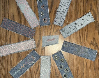 bookmarks made out of denim and personalized with colorful stitching and rivets