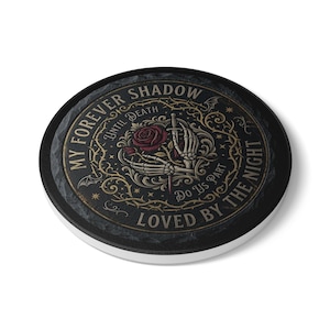 Puede incluir: Posavasos redondo negro con borde blanco. El posavasos presenta un diseño gótico con una mano esquelética sosteniendo una rosa y una espada. El texto incluye "My Forever Shadow Until Death" y "Loved by the Night".