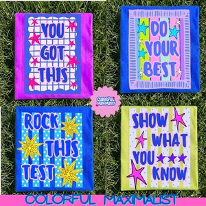 May include: Four rectangular t-shirts featuring graphic prints. Top left is purple with a grid and the text YOU GOT THIS. Top right is blue with vertical stripes and DO YOUR BEST. Bottom left is blue with dots and ROCK THIS TEST. Bottom right is lime green with stripes and SHOW WHAT YOU KNOW.