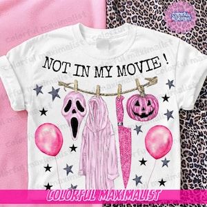 Può includere: Una t-shirt bianca con la scritta NOT IN MY MOVIE! sopra un filo da bucato con una maschera da fantasma rosa, una vestaglia rosa con cappuccio, un coltello rosa glitterato e una zucca rosa. Il design include palloncini rosa e stelle nere.